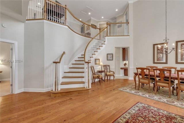 interior space featuring a towering ceiling, hardwood / wood-style floors, and a chandelier