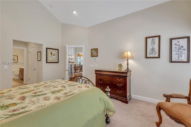 bedroom with high vaulted ceiling, ensuite bath, and light colored carpet