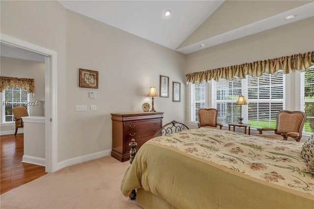 bedroom with multiple windows, vaulted ceiling, and carpet floors