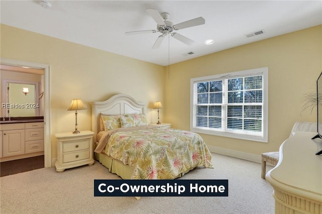 bedroom featuring sink, light colored carpet, ceiling fan, and ensuite bathroom