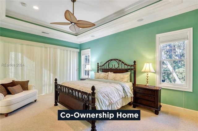 bedroom with ornamental molding, carpet, ceiling fan, and a tray ceiling