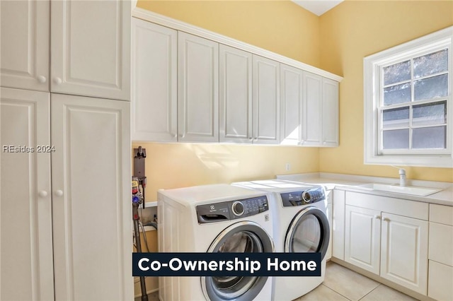 clothes washing area featuring sink, light tile patterned floors, cabinets, and washing machine and clothes dryer