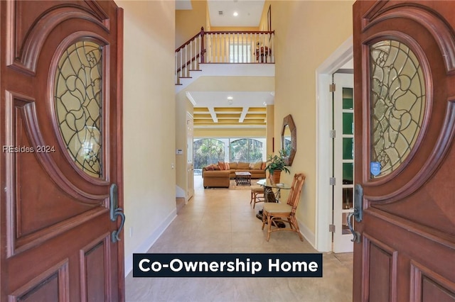 tiled foyer entrance featuring coffered ceiling and beamed ceiling