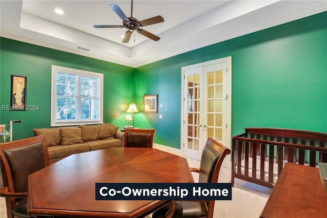 dining area featuring french doors, ceiling fan, and a tray ceiling