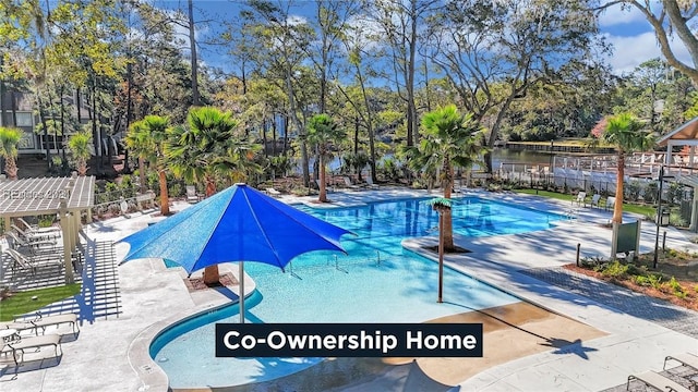 view of swimming pool featuring a patio and a water view