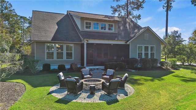 rear view of property with a yard, a patio area, and a fire pit