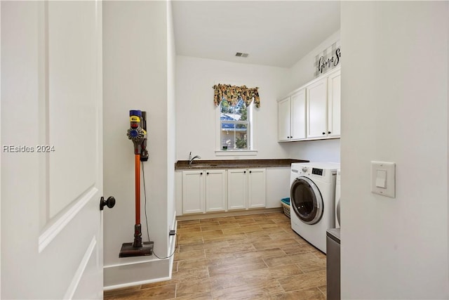 clothes washing area featuring cabinets, separate washer and dryer, and sink