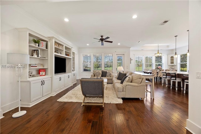 living room with dark hardwood / wood-style flooring, built in features, and ceiling fan