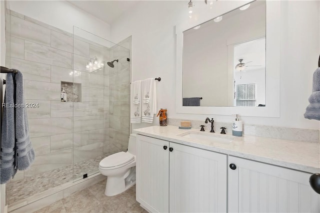 bathroom with ceiling fan, vanity, toilet, and a tile shower