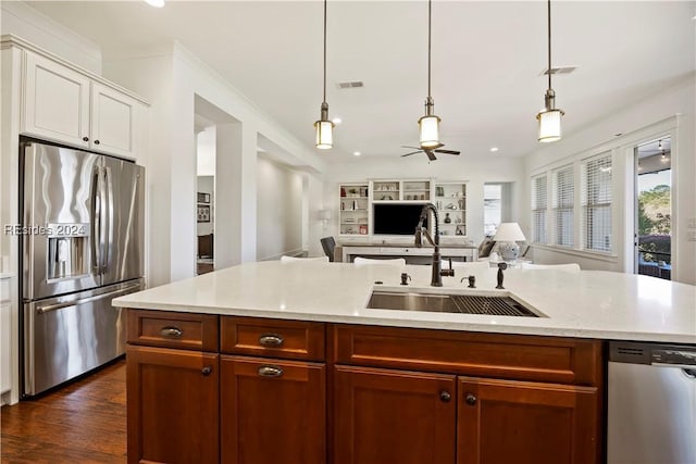 kitchen with stainless steel appliances, sink, a center island with sink, and decorative light fixtures