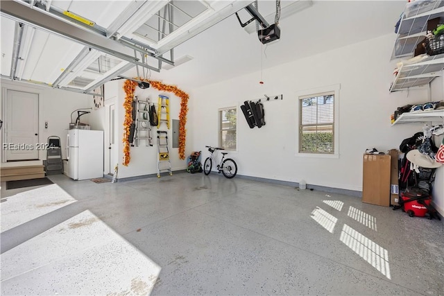 garage with a garage door opener and white fridge