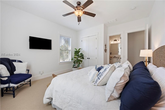 carpeted bedroom featuring a closet, ceiling fan, and ensuite bathroom