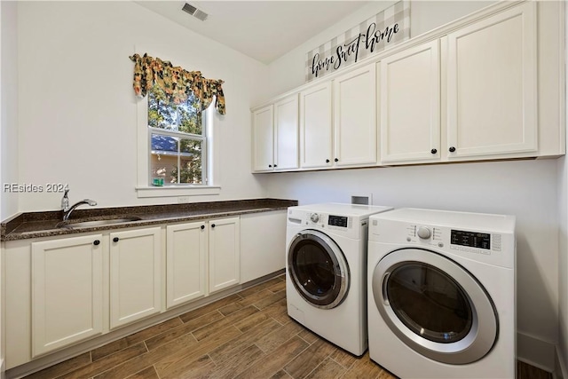 laundry area featuring cabinets, sink, and washing machine and clothes dryer