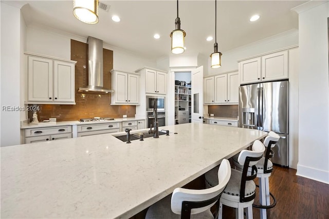 kitchen featuring decorative light fixtures, backsplash, stainless steel appliances, light stone countertops, and wall chimney range hood