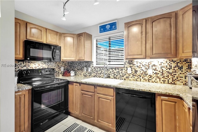 kitchen with sink, black appliances, light stone countertops, light tile patterned flooring, and decorative backsplash