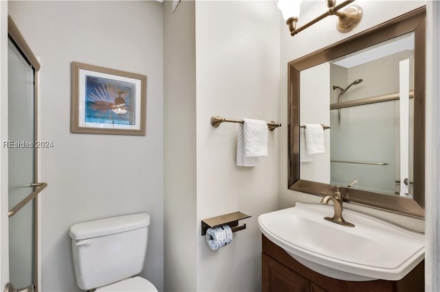 bathroom featuring an enclosed shower, vanity, and toilet