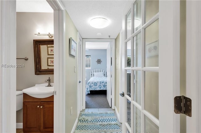 hall with sink and a textured ceiling