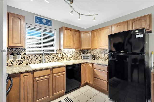 kitchen featuring sink, backsplash, black appliances, and light stone countertops