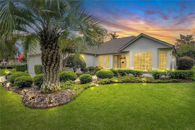 view of front of property featuring a garage and a lawn