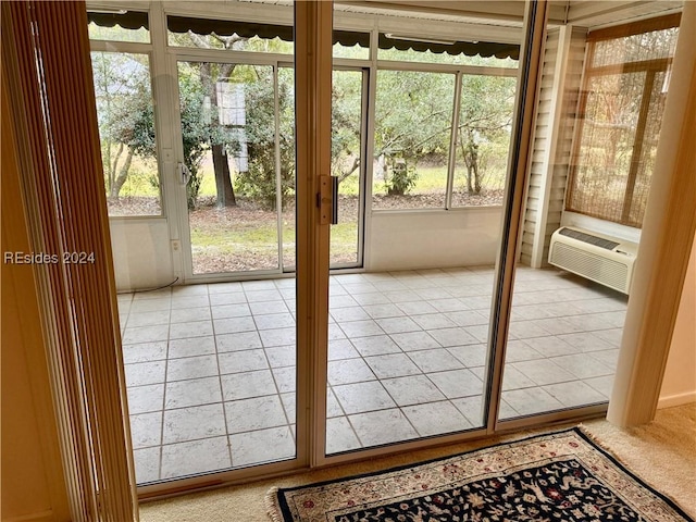 doorway featuring cooling unit, plenty of natural light, and carpet flooring