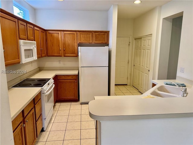 kitchen with sink, white appliances, and light tile patterned floors