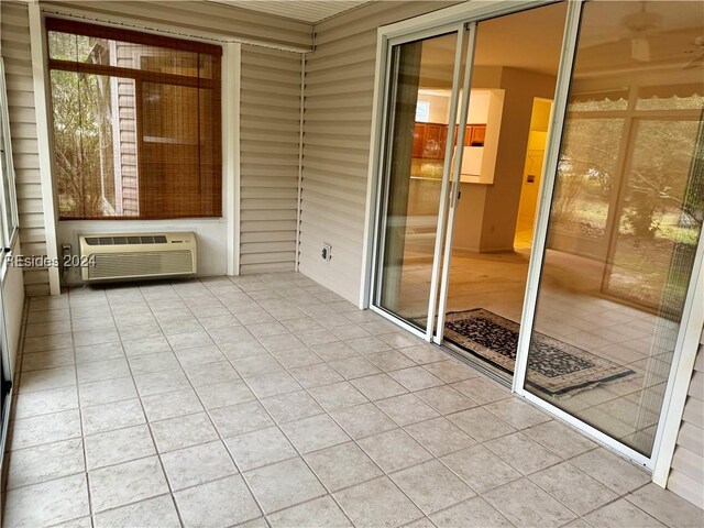 unfurnished sunroom with an AC wall unit