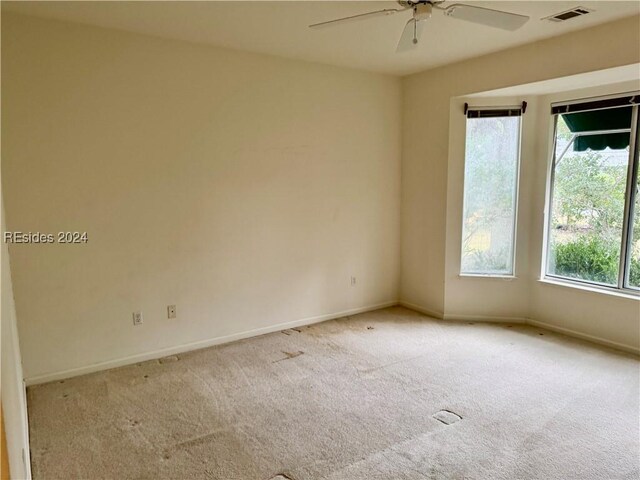 unfurnished room with light carpet and ceiling fan