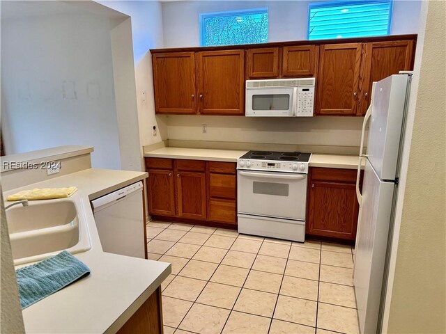 kitchen featuring sink, white appliances, and light tile patterned flooring