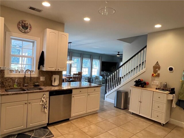 kitchen with sink, white cabinetry, hanging light fixtures, light tile patterned floors, and stainless steel dishwasher