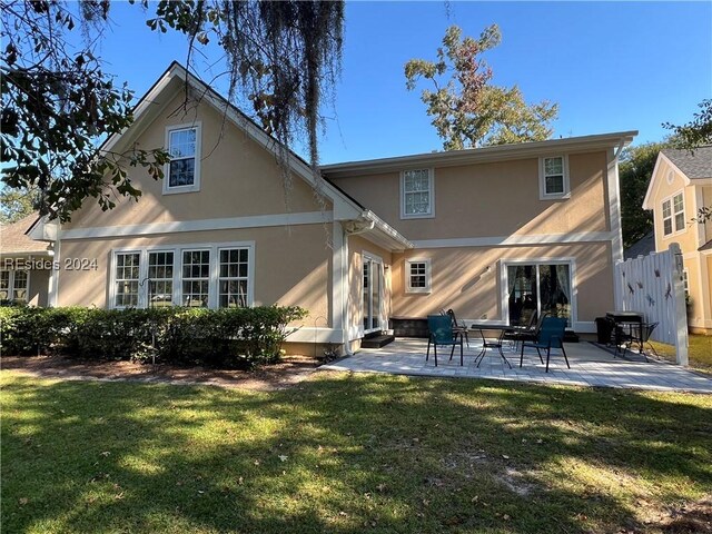 back of house with a patio area and a lawn