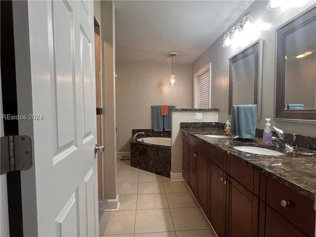 bathroom with tiled tub, vanity, and tile patterned floors