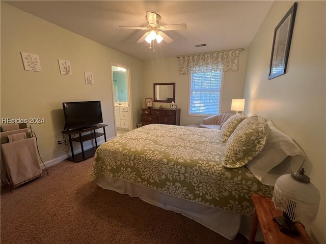 carpeted bedroom with ensuite bath and ceiling fan