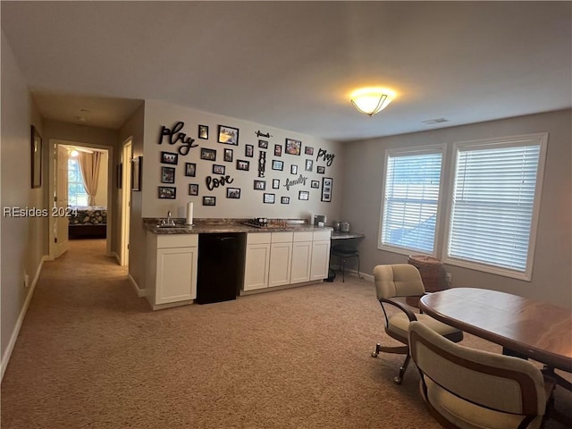 kitchen featuring light colored carpet, dishwasher, sink, and white cabinets