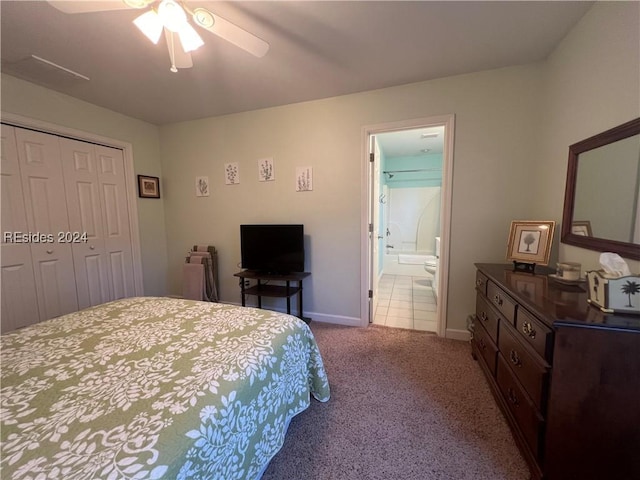 carpeted bedroom featuring ensuite bathroom, ceiling fan, and a closet