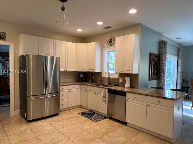 kitchen with white cabinetry, appliances with stainless steel finishes, sink, and kitchen peninsula