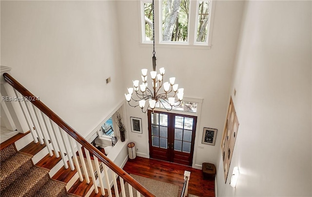 foyer featuring french doors, a towering ceiling, and dark wood-type flooring