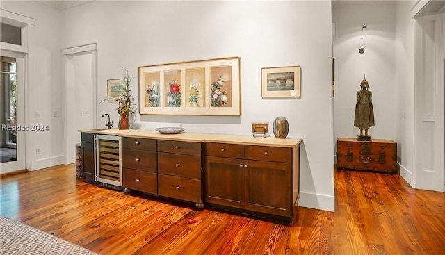 bar featuring wine cooler, sink, and dark hardwood / wood-style flooring