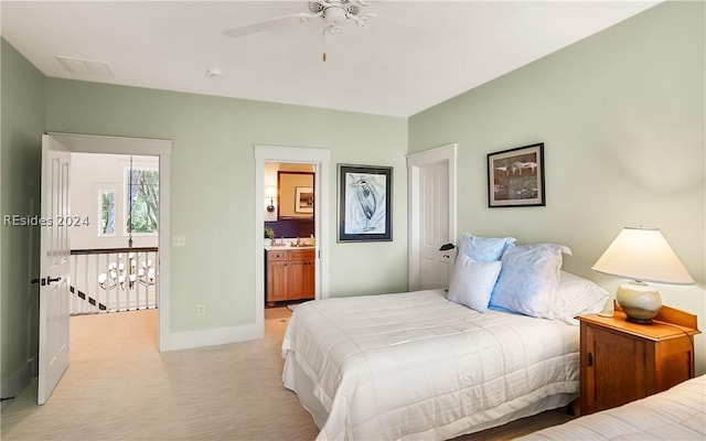 bedroom with light carpet, connected bathroom, and ceiling fan