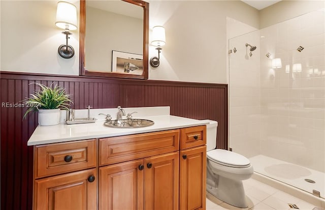 bathroom with vanity, toilet, and tiled shower