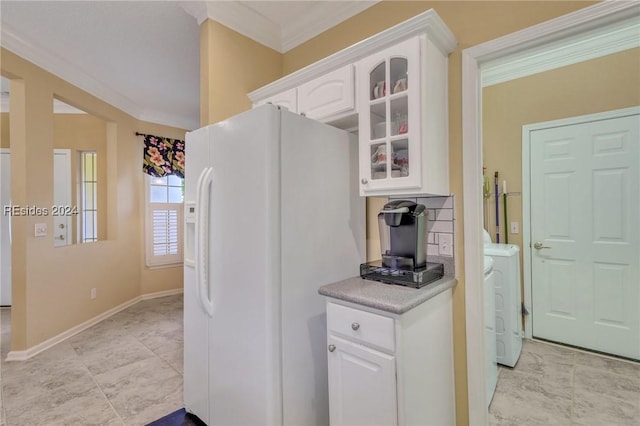 kitchen with white cabinetry, white refrigerator with ice dispenser, ornamental molding, and washer and clothes dryer