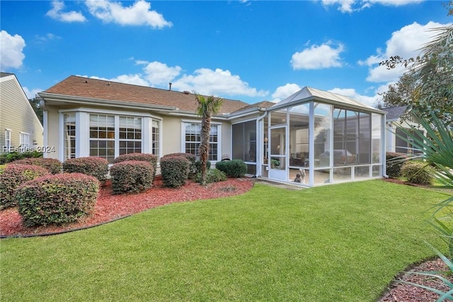 back of property with a yard and a sunroom