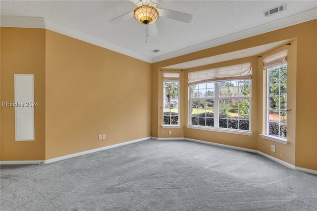 carpeted empty room with crown molding, ceiling fan, and a textured ceiling