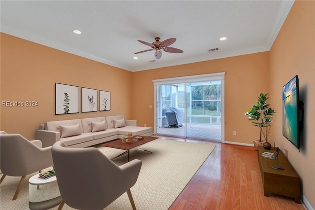 living room with ornamental molding, ceiling fan, and light hardwood / wood-style flooring