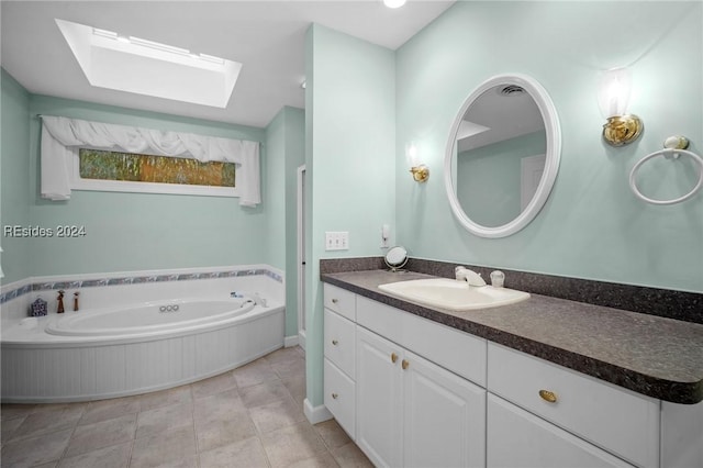 bathroom featuring tile patterned flooring, vanity, a washtub, and a skylight