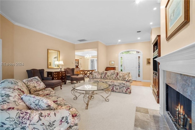 living room featuring crown molding, a fireplace, and an inviting chandelier