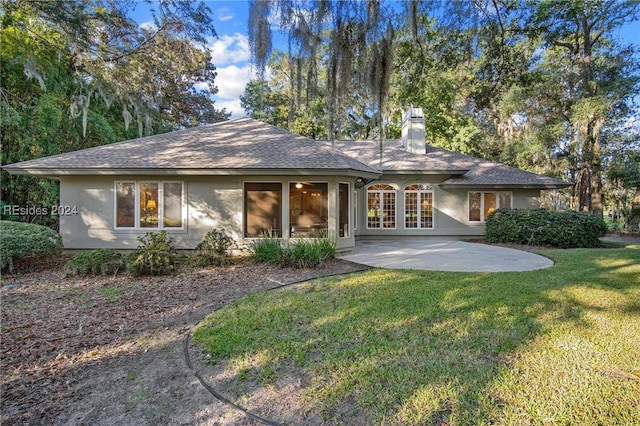 rear view of house with a patio area and a lawn