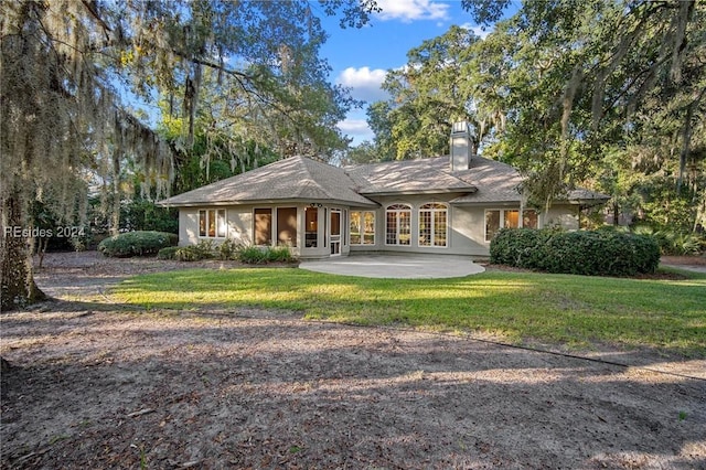 back of property featuring a yard and a patio