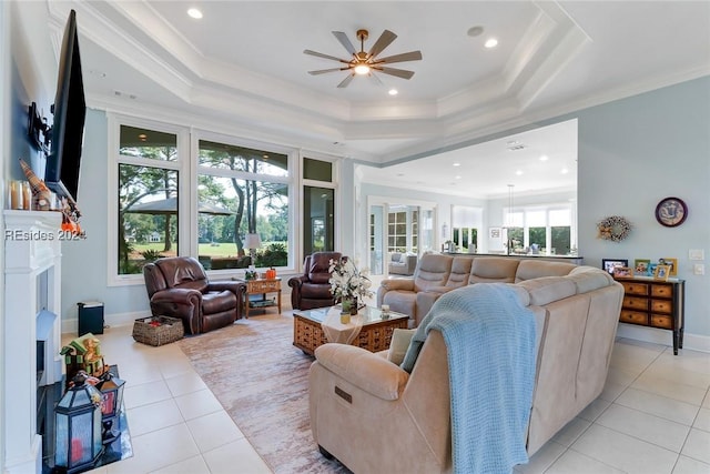 tiled living room featuring ceiling fan, ornamental molding, and a raised ceiling