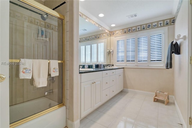 bathroom featuring tile patterned flooring, enclosed tub / shower combo, vanity, and crown molding