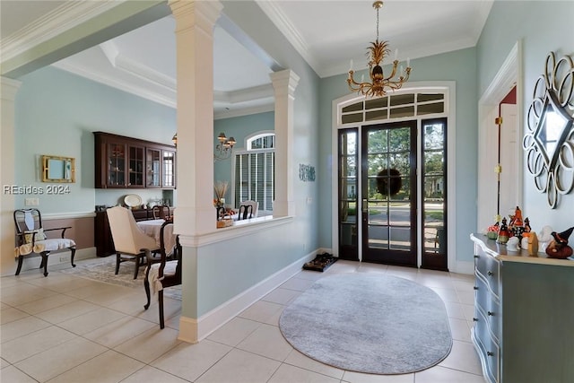 entryway featuring light tile patterned flooring, ornamental molding, a chandelier, and ornate columns